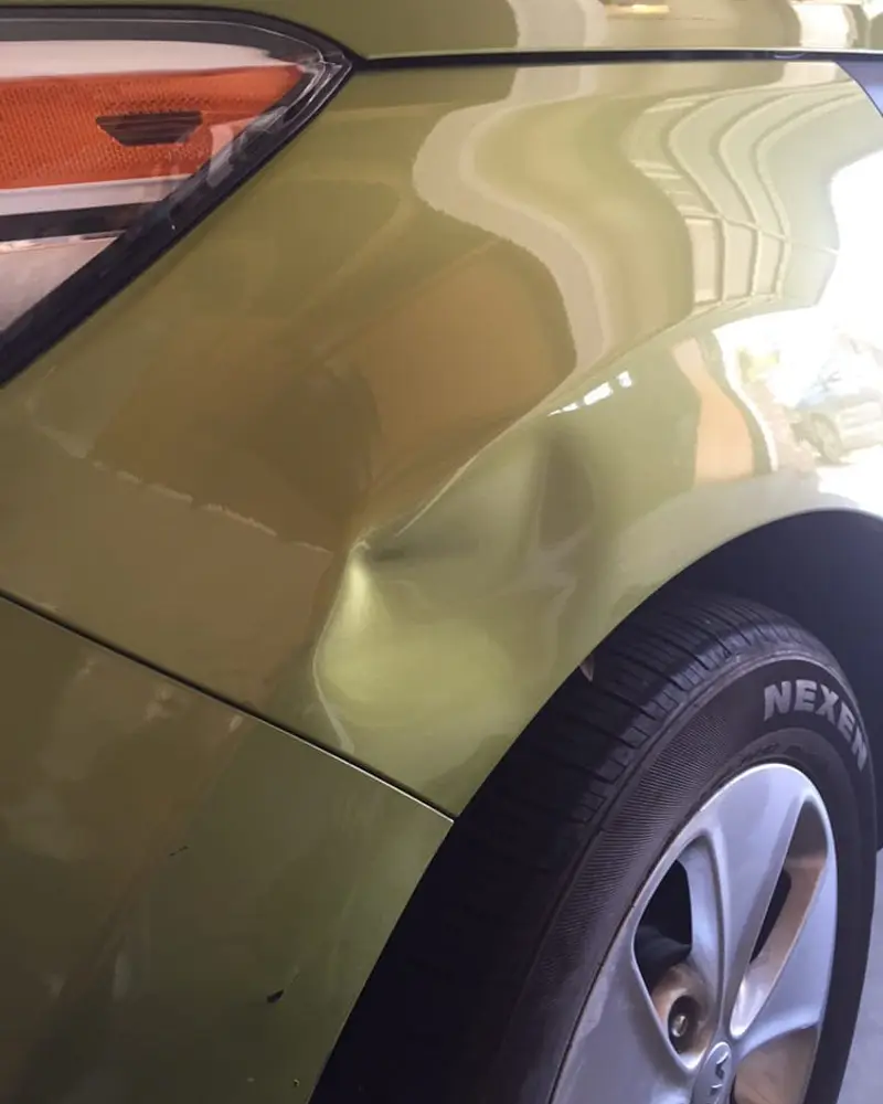 Before: Dent above the rear wheel