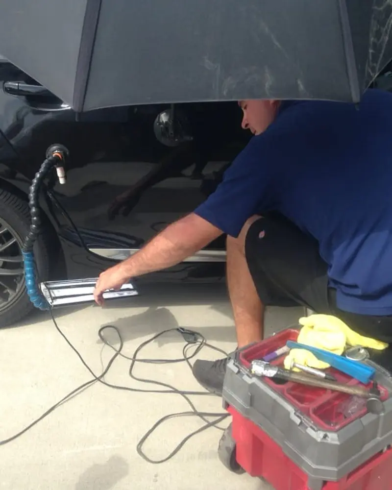 Dent repair underway in a customer’s driveway