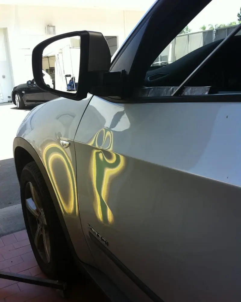 Light reflected across a silver door to check the repair