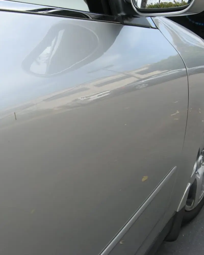 After: Silver door, low dent below the handle line